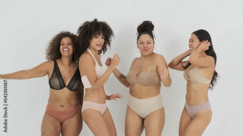 Delighted young body positive multiethnic female models dancing in studio