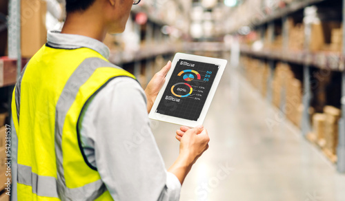 Portrait asian engineer man shipping order detail on tablet check goods and supplies on shelves with goods background inventory in factory warehouse.logistic industry and business export