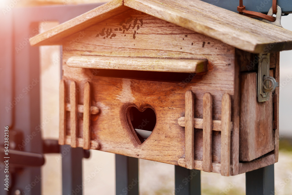 Wooden mailbox with a carved slot in a heart shape with a letter Wooden mailbox with a carved slot in a heart shape with a letter