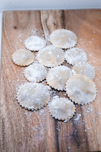 fresh raw pasta handmade uncooked raviolis wood table flour