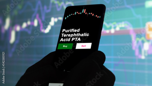 An investor's analyzing the Purified Terephthalic Acid PTA etf fund on screen. A phone shows the ETF's prices purified terephthalic acid pta to invest photo
