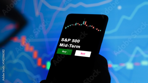 An investor's analyzing the S&P 500 Mid-Term etf fund on screen. A phone shows the ETF's prices sandp 500 mid term to invest photo