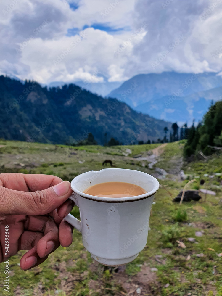 Obraz premium A selective focus on Tea Cup at Blur Top Mountain View of Kalam Valley in Clouds 