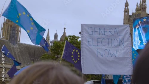 General election sign being held high in protest near pro EU signs in London UK