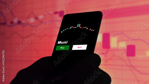 An investor's analyzing the Muni etf fund on screen. A phone shows the ETF's prices muni to invest photo