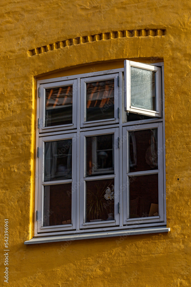 Copenhagen, Denmark An open window on a yellow facade in Christianshavn.