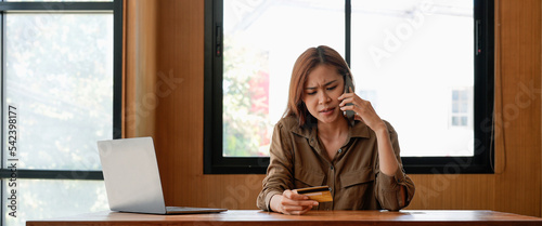 Angry and furious young Asian woman calling credit card call-centre service to complain about her problems. Online payment, Internet banking concept