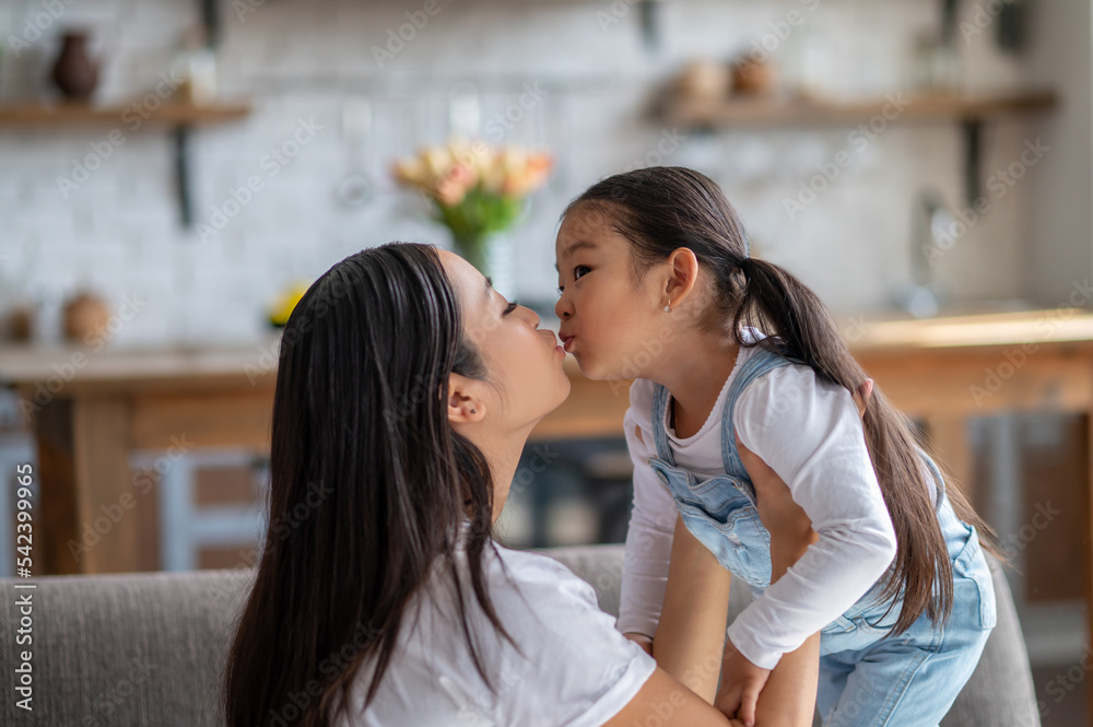 Loving mother giving a kiss to her child Loving mother giving a kiss to her child