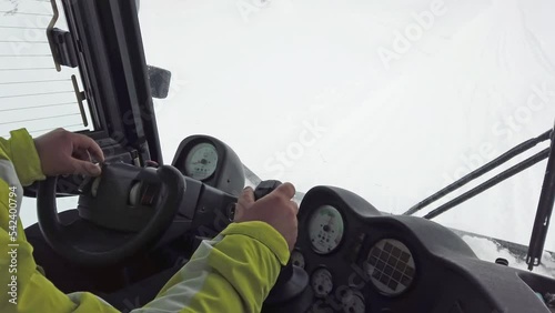 Pov drive of snowplow ratrack machine during skier, mountaineer, hiker, rescue mission on peak at snow storm photo