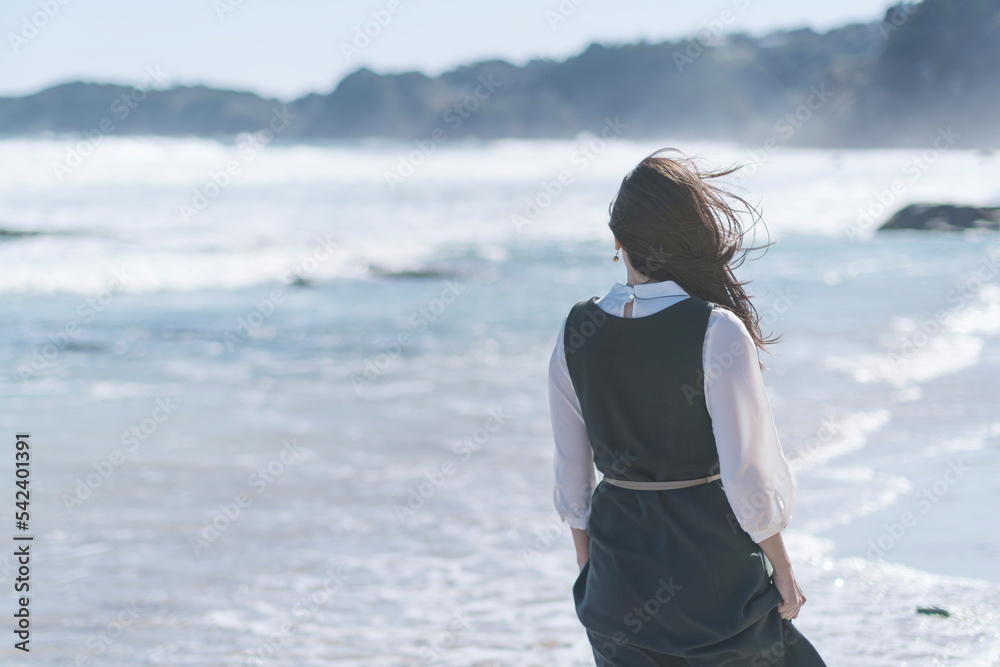 波打ち際で潮風を受けながら海を眺める女性 Stock 写真 | Adobe Stock