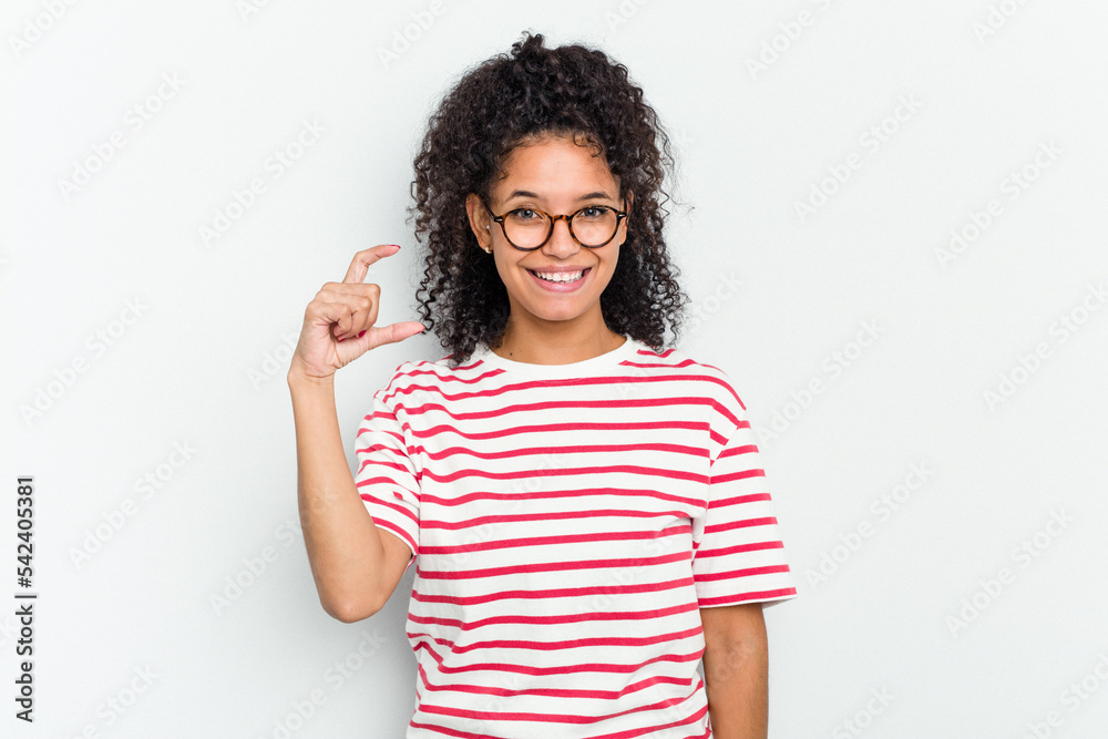Young african american woman isolated holding something little with forefingers, smiling and confident.