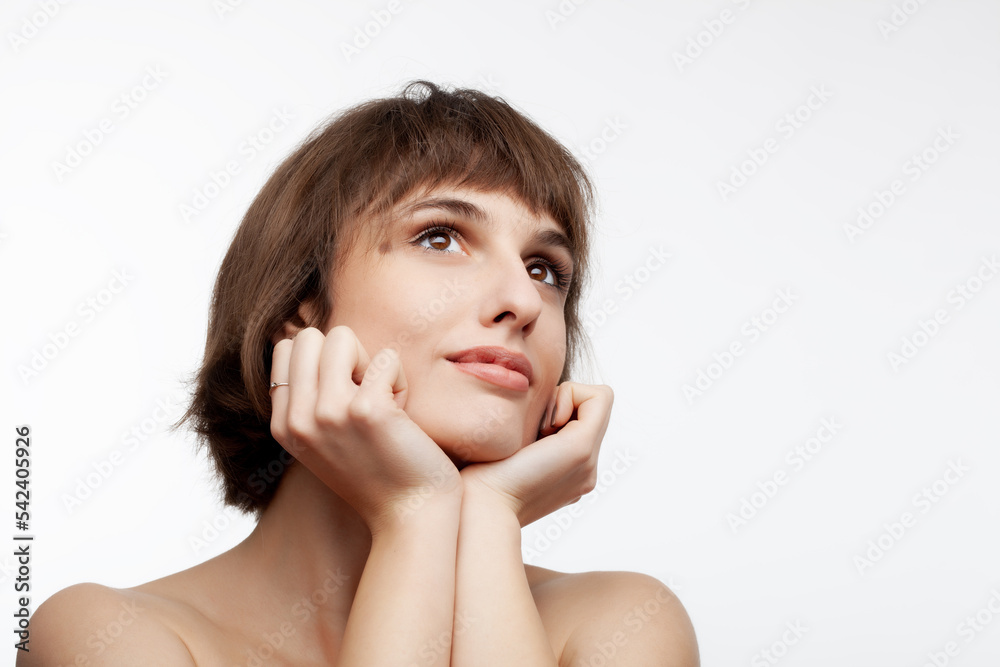 studio portrait of a beautiful brunette girl with short hair looking up isolated on white background. studio portrait of a beautiful brunette girl with short hair looking up isolated on white background.