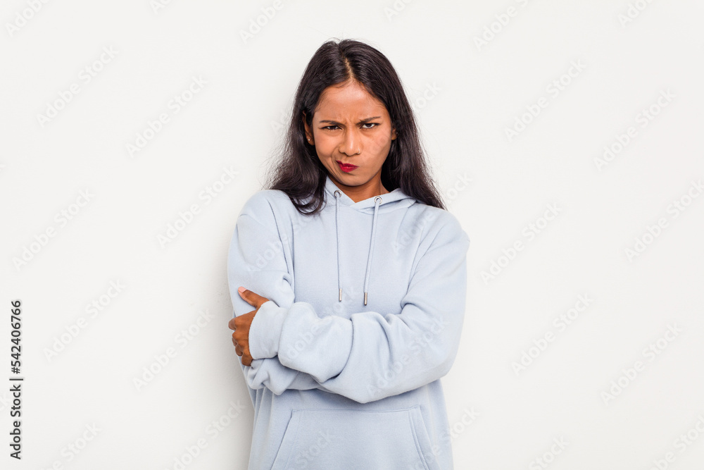 Young Indian woman isolated on white background frowning face in displeasure, keeps arms folded. Young Indian woman isolated on white background frowning face in displeasure, keeps arms folded.