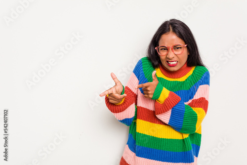 Young Indian woman isolated on white background pointing with forefingers to a copy space  expressing excitement and desire.