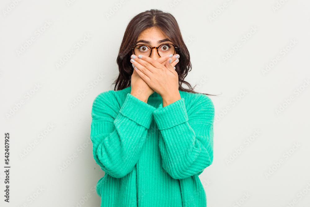 Young Indian woman isolated on white background shocked covering mouth with hands.