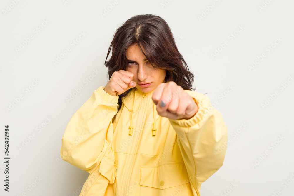 Young Indian woman isolated on white background throwing a punch, anger, fighting due to an argument, boxing.
