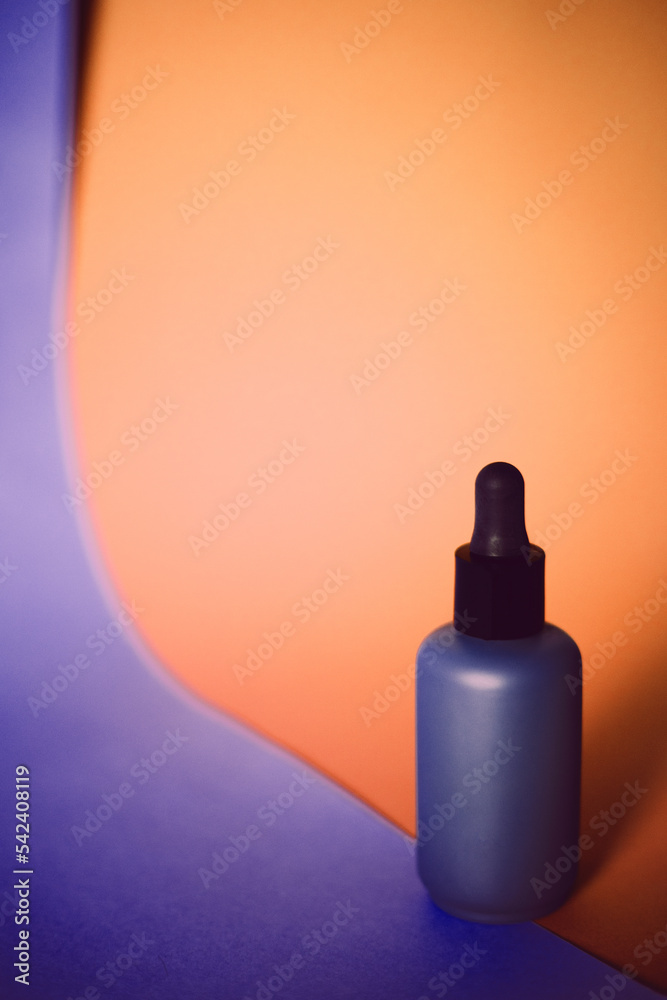 Skin care lotion or serum on orange background.