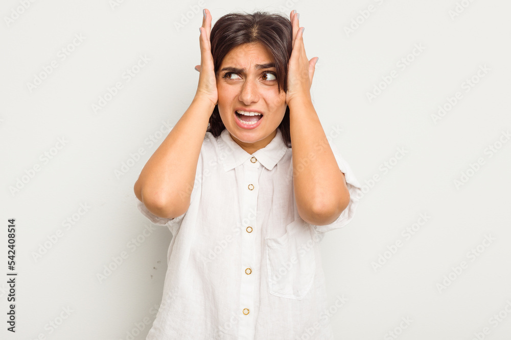 Young Indian woman isolated on white background covering ears with hands trying not to hear too loud sound. Young Indian woman isolated on white background covering ears with hands trying not to hear too loud sound.