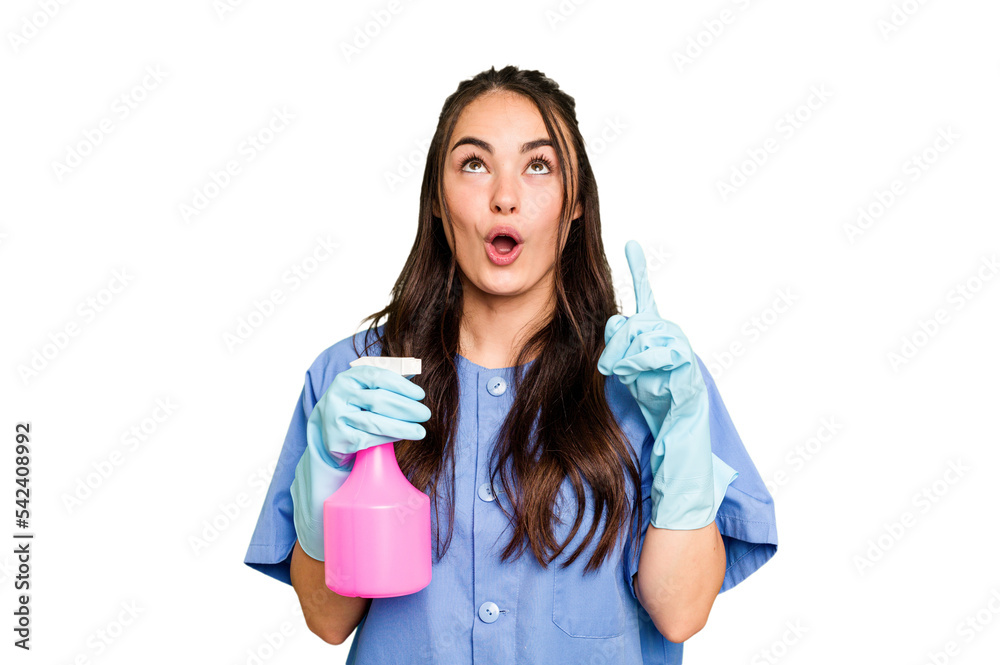 Young cleaner caucasian woman isolated on green chroma background pointing upside with opened mouth. Young cleaner caucasian woman isolated on green chroma background pointing upside with opened mouth.