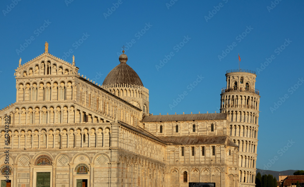 Pisa tower and cathedral sunset light colors against blue sky