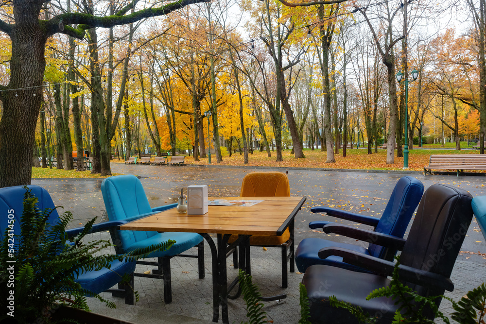 Table and chairs of outdoor cafe in autumn park Kharkiv city, Ukraine