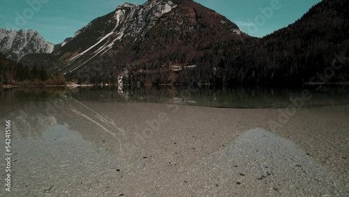 Lake Predil or Raibler See is a green mountain lake near Tarvisio, Austria and Slovenia in Julian alps. In the valley of pine trees in the fall.  photo