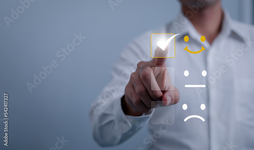 Customer Satisfaction service and Satisfaction concept ,Business people are touching the virtual screen on the happy Smiley face icon to give satisfaction in service. rating very impressed.