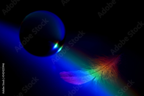 黒い背景に浮かぶ羽とクリスタルと虹色の光