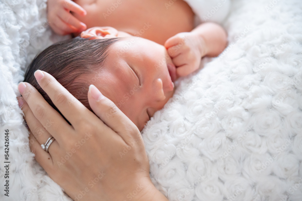 Φωτογραφία ママに撫でられてスヤスヤ眠る生まれたての赤ちゃん