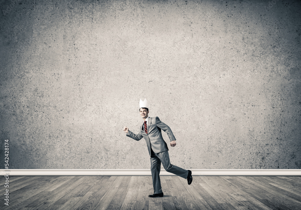 King businessman in elegant suit running in empty room King businessman in elegant suit running in empty room