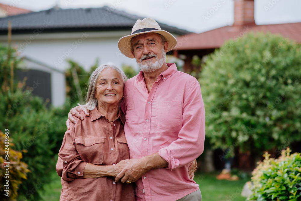 Senior couple in love posing together in their garden. Senior couple in love posing together in their garden.