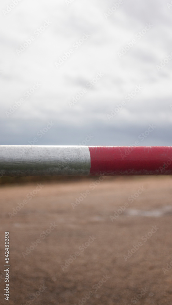 Barra metálica en roja y blanca en campo