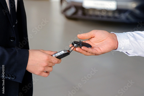 Car salesman gives the keys to the customers who signed the purchase contract