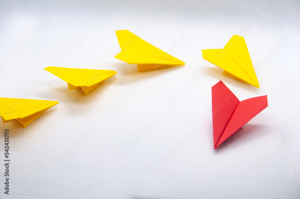 Red paper plane origami leading yellow planes on white background. Leadership concept. Red paper plane origami leading yellow planes on white background. Leadership concept.