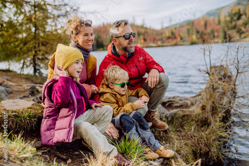 Canvas Print Happy young family with little children, resting near lake in mountains
