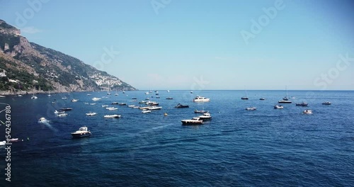 Hundred of boats, yachts, sailboat at mediterannean sea. Summer holiday at the Amalfi coast, Italy. Ships are anchored in the port of Postitano, Naples. Landscape panorama drone aerial view.  photo