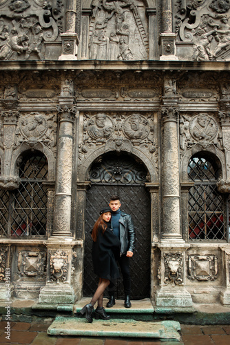 Luxury couple posing near a black door. 