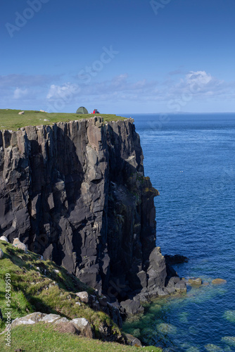 A woman camps at the Neist Cliff lookout at Neist Point Lighthouse on the Isle of Skye in the Scottish Highlands