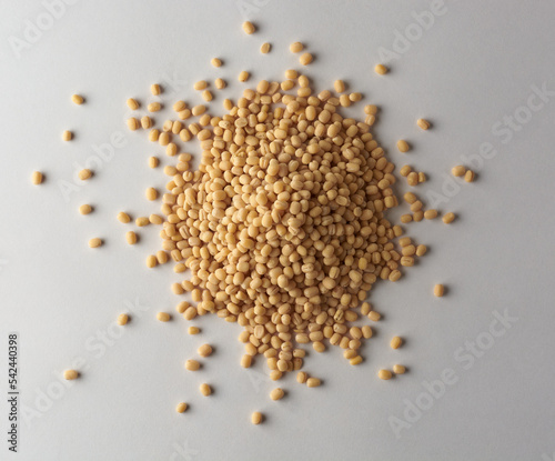 pile of organic polished white urad dal isolated on neutral grey background, vigna mungo, also known as ulundu paruppu, or urad bean or mash kalai, taken straight from above photo