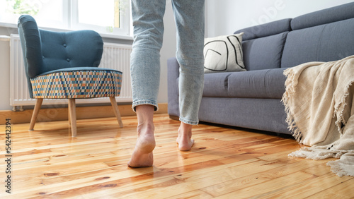 woman in jeans walking barefoot in room photo