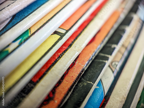 Old vintage comic books stack creates colorful background paper texture with abstract shapes
