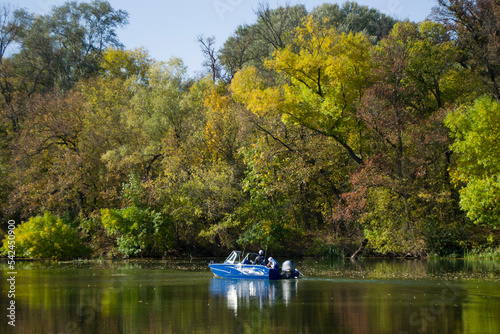 Fishermen in a motor boat go fishing in autumn