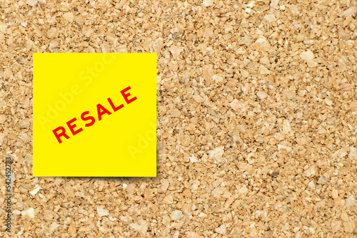 Yellow note paper with word resale on cork board background with copy space
