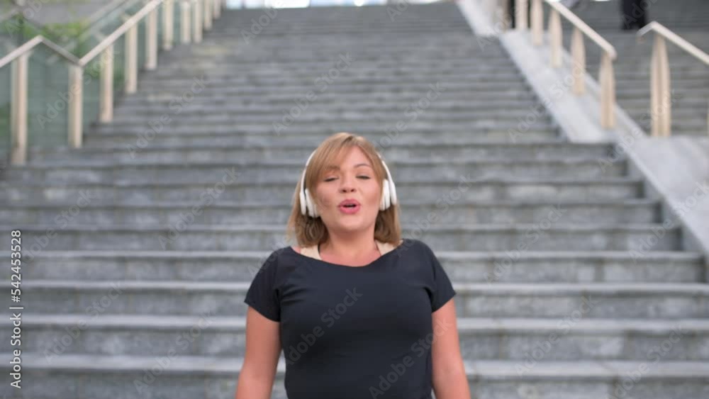Sporty woman running outdoor, body positive and healthy lifestyle concept, curvy young girl jogging, happy plus size woman doing steps and smiling