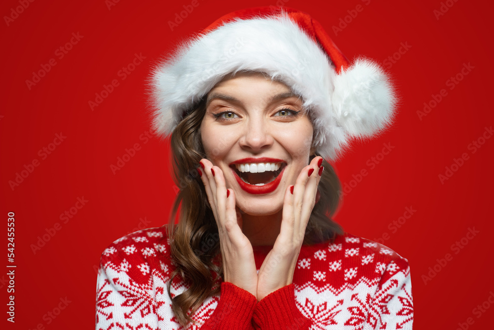 Surprise, happy woman in santa hat has excited face wow expression, isolated on red Surprise, happy woman in santa hat has excited face wow expression, isolated on red