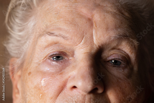 close up of white-haired Caucasian elderly woman crying tears