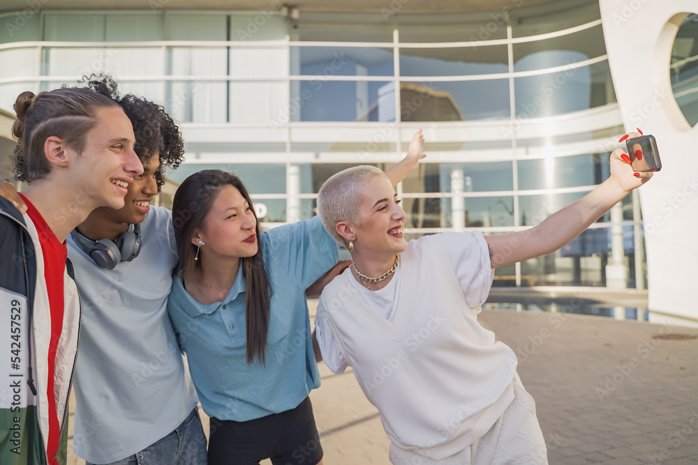 Multiethnic teenage friends taking a selfie group photo and laughing happy in the campus. Technology lifestyle concept. Multiethnic teenage friends taking a selfie group photo and laughing happy in the campus. Technology lifestyle concept.