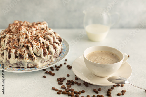 Coffee with cream in a white set with coffee beans  cream cake. Drink on a light gray background.
