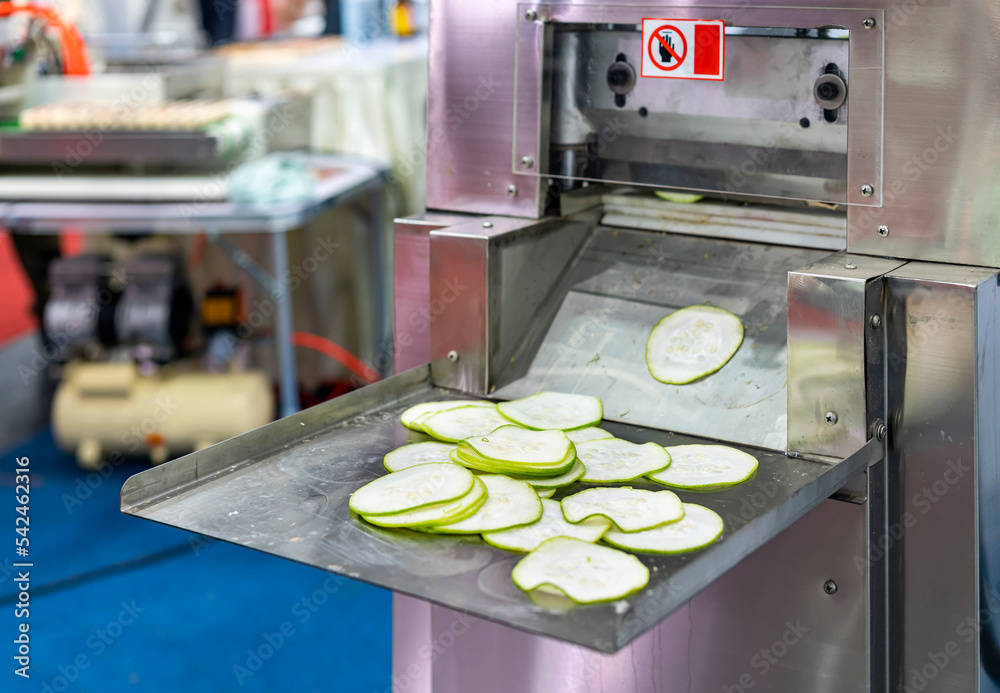 Sliced Cucumber slices on support plate after process chopping by automatic  commercial vegetable slicer machine for food industrial Stock Photo