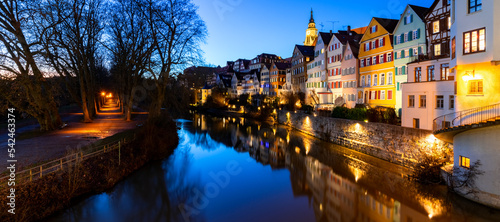 Panoramic view of old town houses in Tübingen Germany. Colorful facades mirroring in Neckar river on a winters day at blue hour evening twilight. Picturesque tourist attraction called “Neckarfront“.